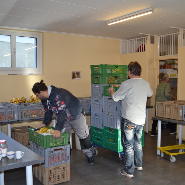 Freiwillige tragen Kisten und sortieren Lebensmittel