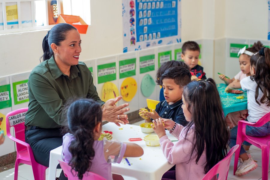 Kita-Szene: Kinder und Kita-Leiterin am Basteltisch